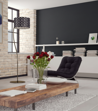 Nowoczesny salon z ciemno szarą ścianą i ceglaną ścianą
