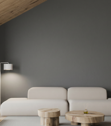 Salon w nowoczesnym stylu z szarą ścianą i drewnianym sufitem. Jasne meble i minimalistyczne dodatki.