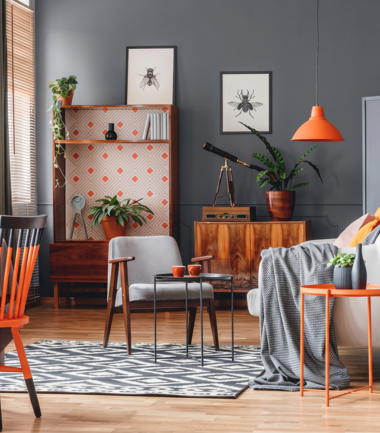 Salon w stylu vintage z szarymi ścianami w kolorze RAL 7043 i akcentami pomarańczowymi