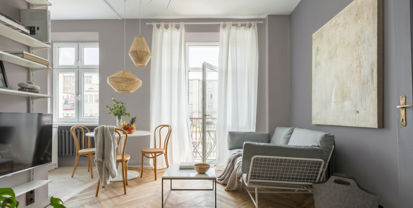 Salon w stylu skandynawskim z szarymi ścianami i drewnianą podłogą